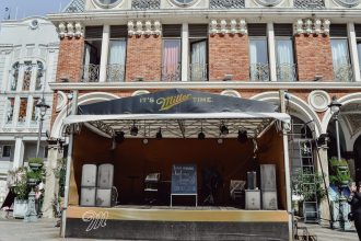 Palco de música ao ar livre montado diante de uma fachada histórica ricamente detalhada.