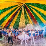 Participantes apresentam uma dança tradicional diante do público em um festival cultural brasileiro.