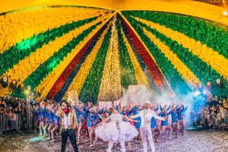 Pessoas participam de uma apresentação de dança em um festival colorido no Brasil.