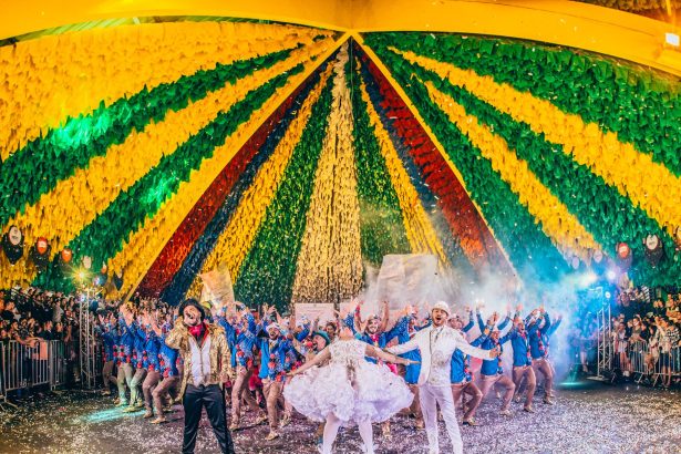 Pessoas participam de uma apresentação de dança em um festival colorido no Brasil.
